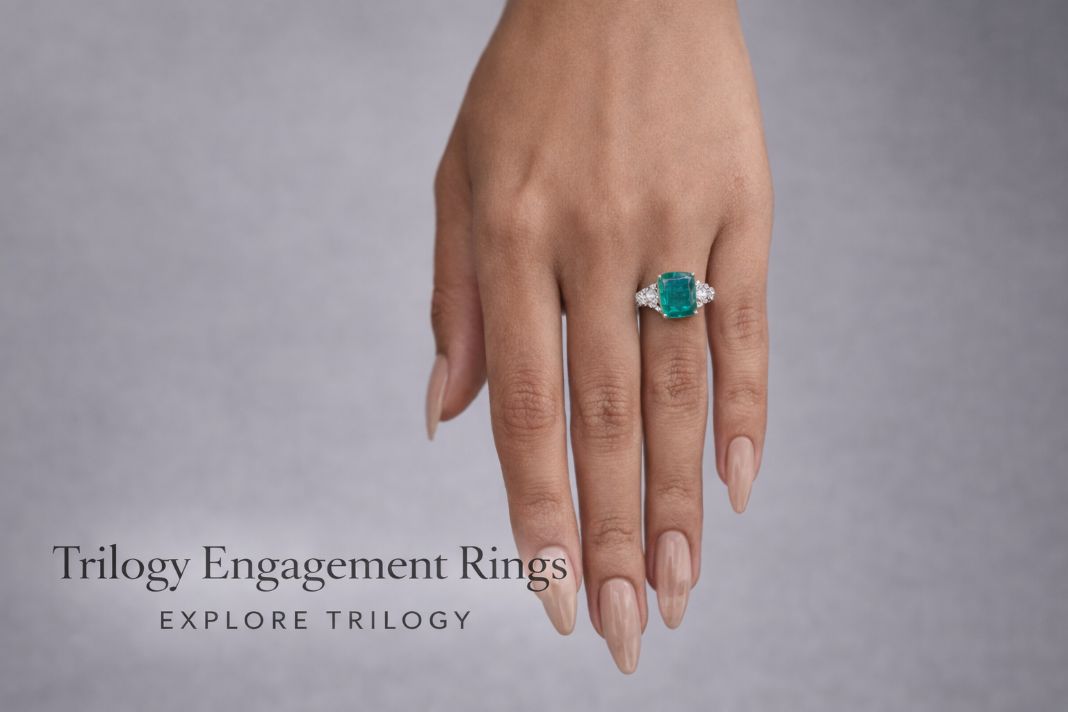 Emerald and diamond trilogy ring downward hand grey sweep