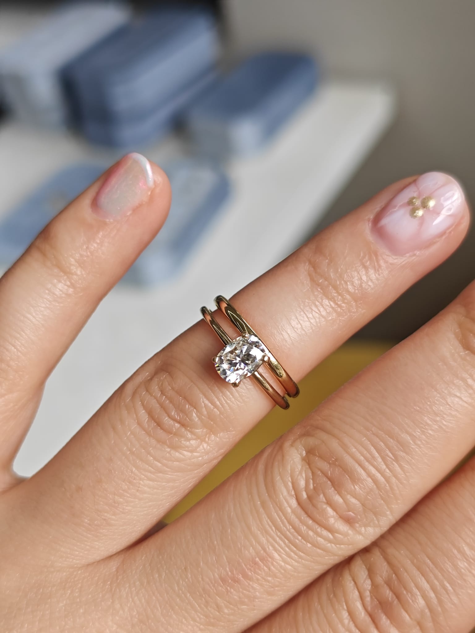Two-ring set with a central gemstone on a plain band, displayed on a hand. Elegant engagement and wedding ring combination. - Sample Image